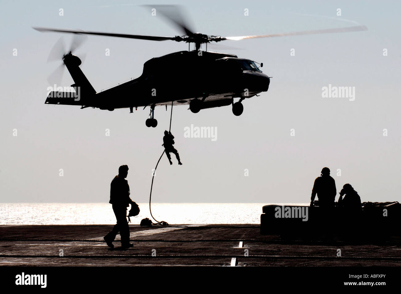 Il personale fast-corda al di fuori di un SH-60F Seahawk elicottero Foto Stock