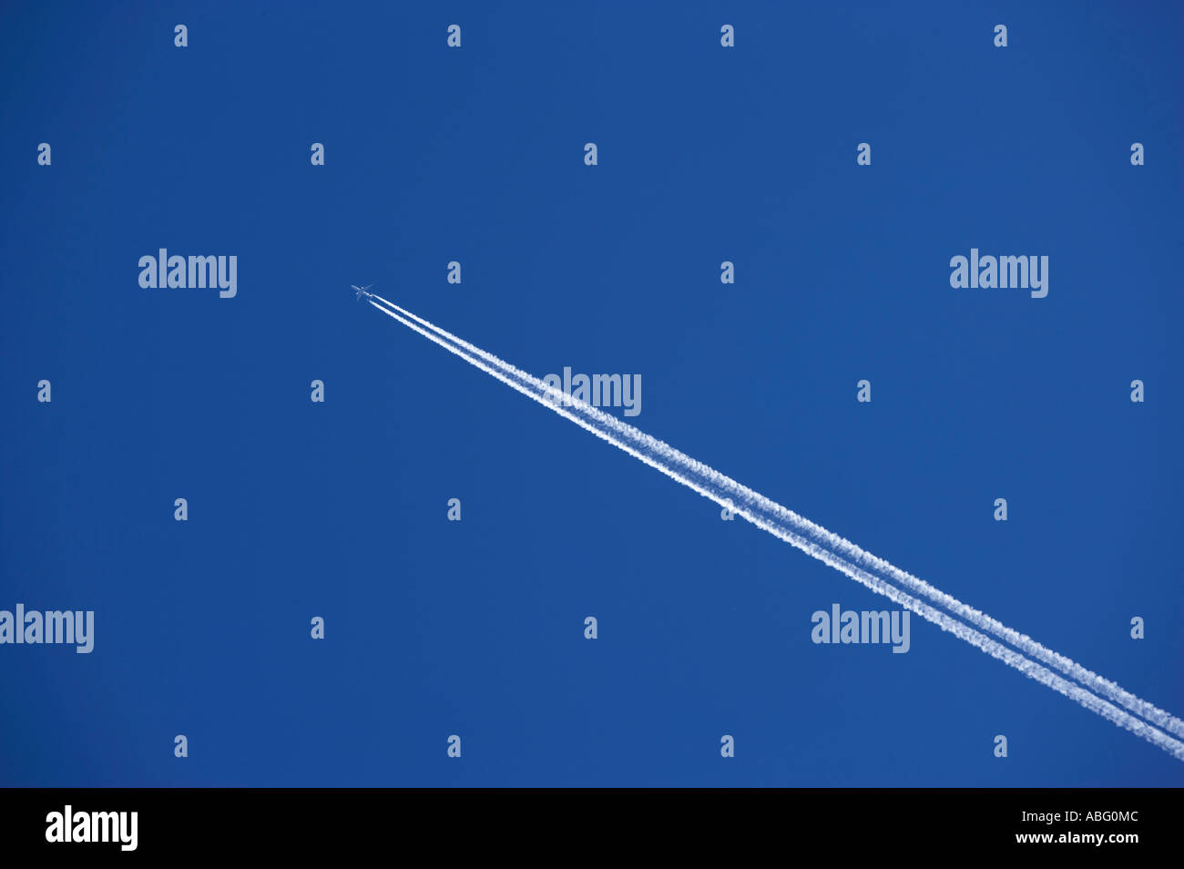 Aereo JET con vapore di scarico sentieri nel cielo blu chiaro Foto Stock