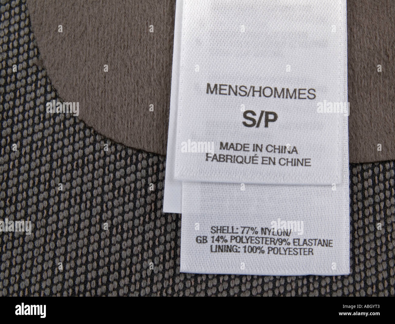 Etichetta bianco taglie in stretta fino a parole in francese e in inglese su uomini top realizzato in Cina Foto Stock