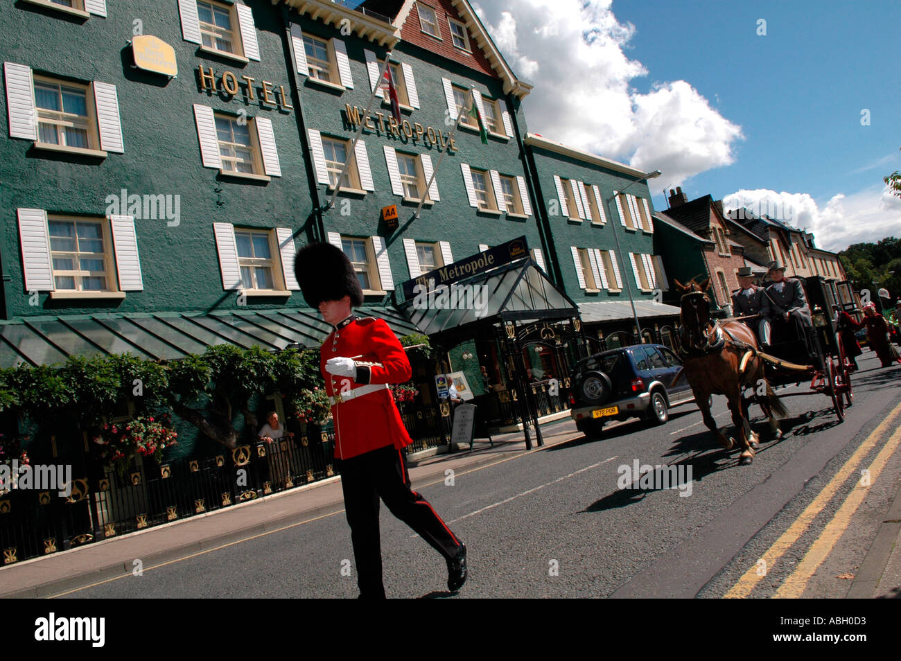 Guardsman nel periodo uniforme processione leader a Llandrindod Wells Festival Vittoriano passato l'Hotel Metropole Powys Galles Centrale Foto Stock