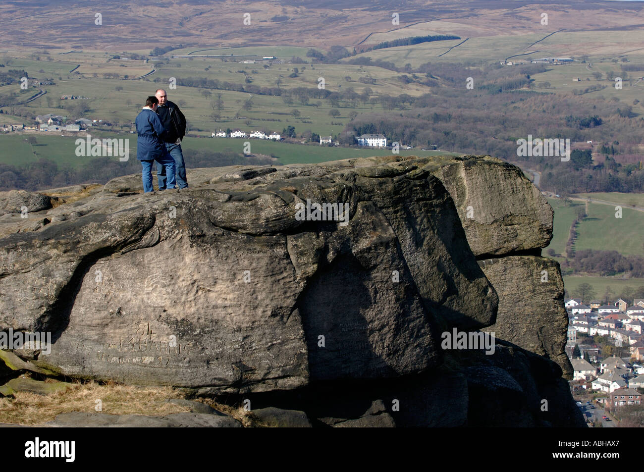 Gli escursionisti a piedi e guardare oltre il bordo della mucca e rocce di vitello, Ilkley, West Yorkshire, Regno Unito. Foto Stock