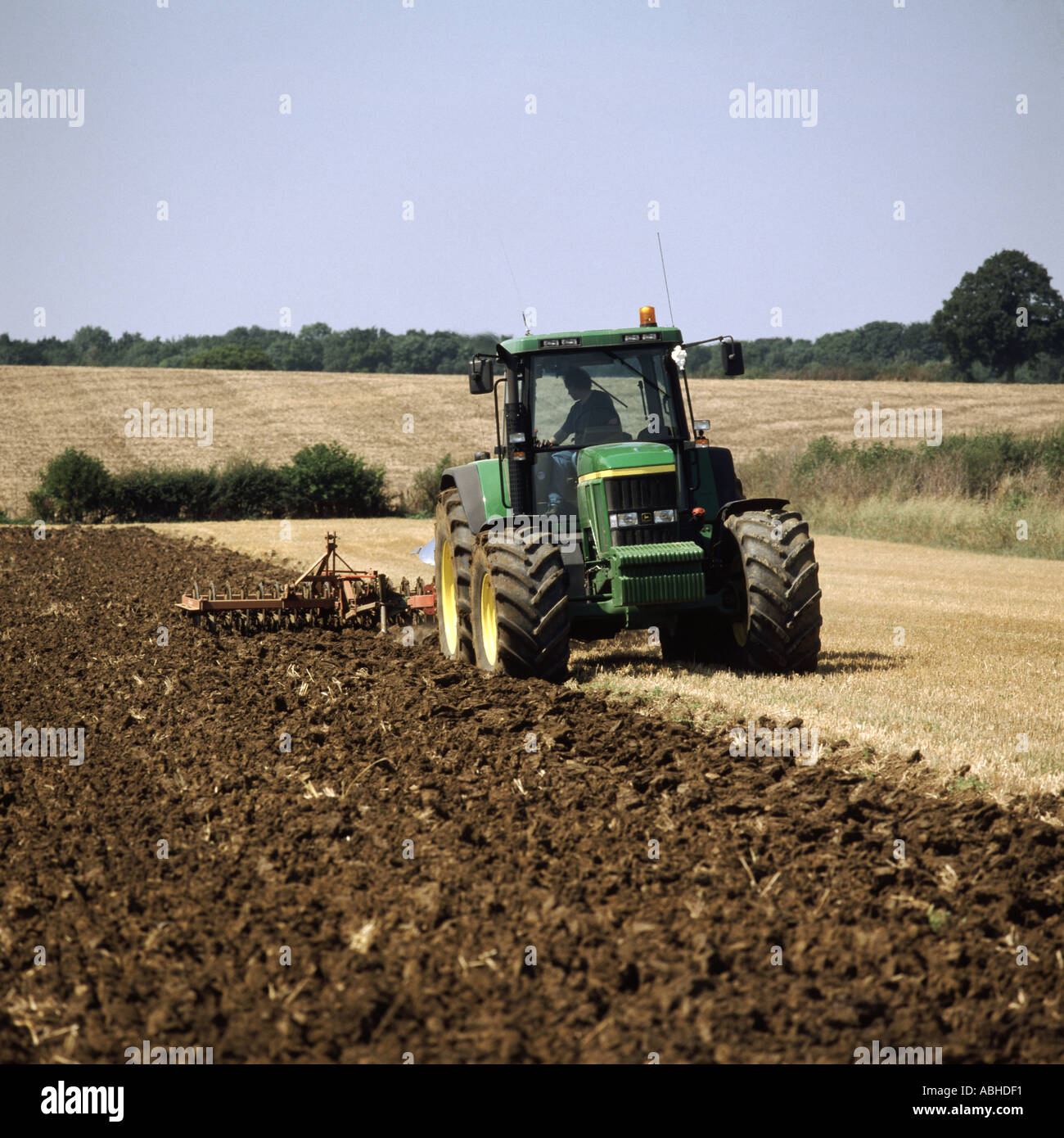 John Deere sette coulter aratro e premere coltivazione di stoppia campo in Cotswolds REGNO UNITO Foto Stock