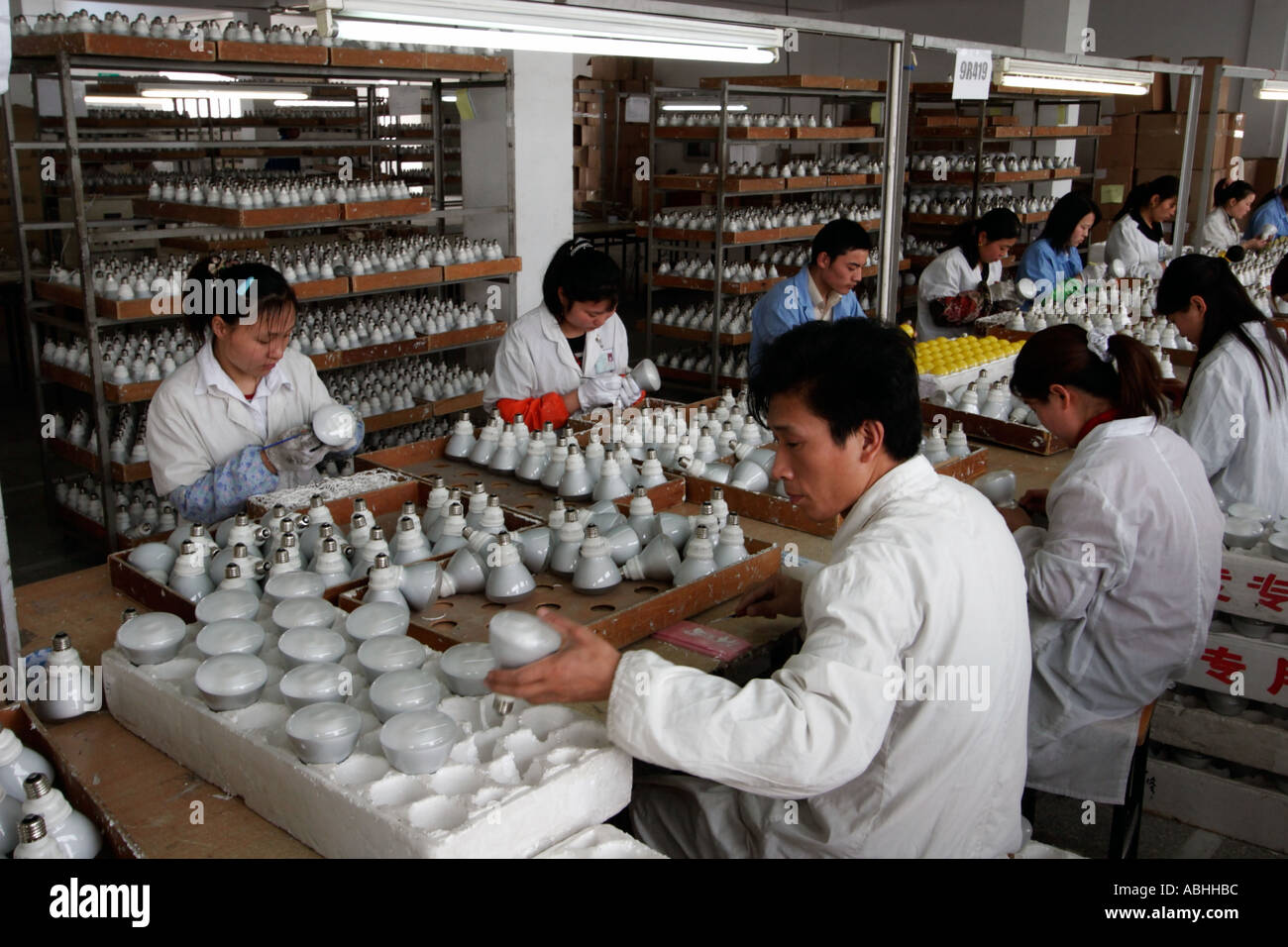Un operaio di fabbrica carichi di illuminazione finito prodotti presso la sua stazione di Shanghai in Cina Foto Stock