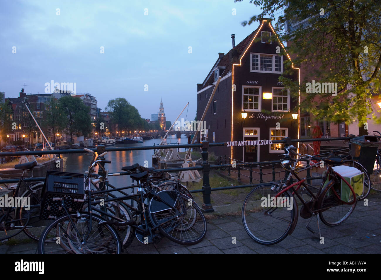 Biciclette davanti a de Sluyswacht un brown cafè in serata Oude Schans Amsterdam Olanda Paesi Bassi Foto Stock