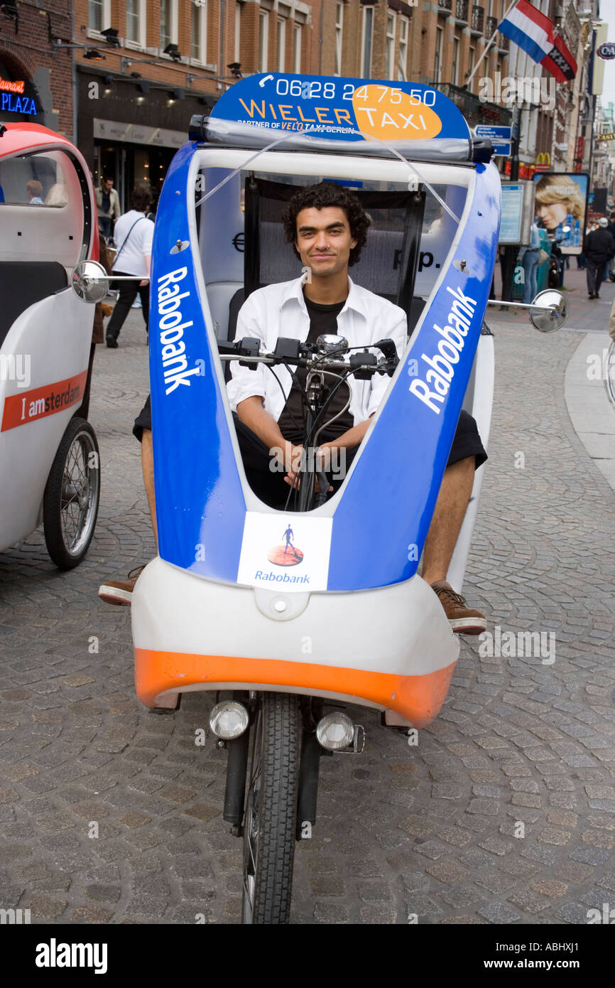 Uomo sorridente in seduta ciclomotore taxi Damrak Amsterdam Olanda Paesi Bassi Foto Stock