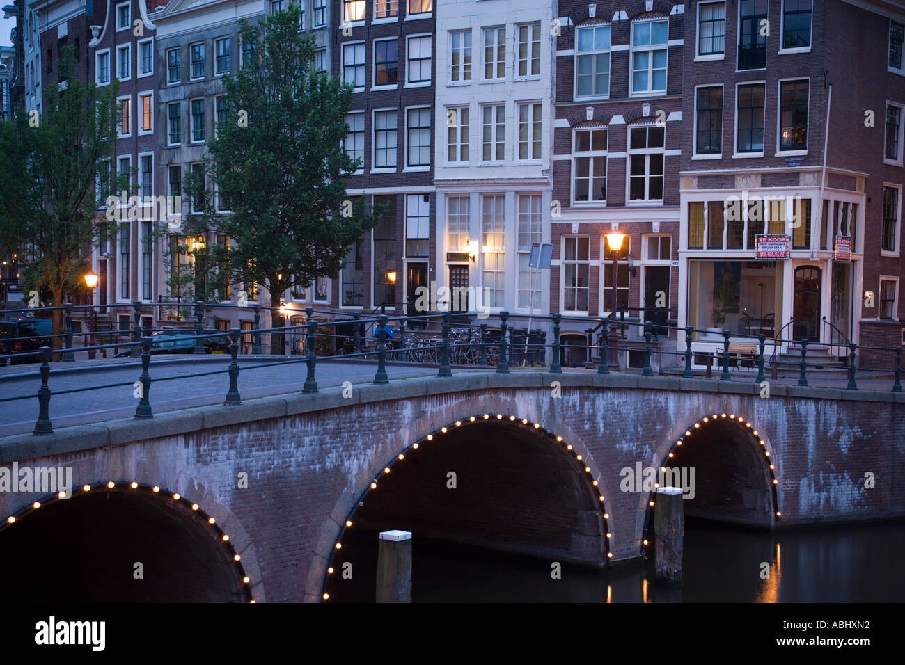Vista su ponte illuminato di case a capanna in serata Keizersgracht e Leidsegracht Amsterdam Olanda Paesi Bassi Foto Stock