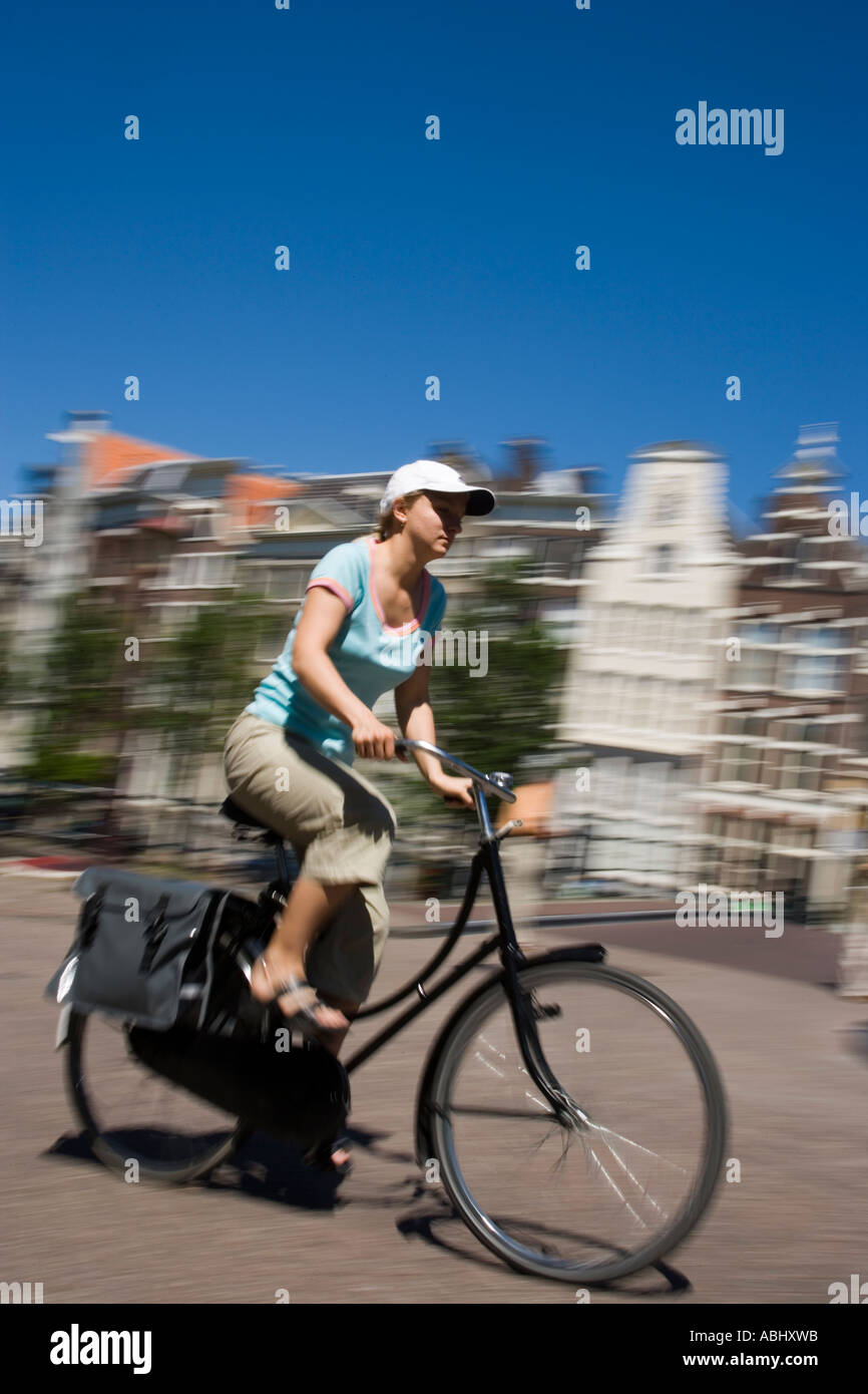 Donna in bicicletta lungo Keizersgracht sfocato Amsterdam Olanda Paesi Bassi Foto Stock