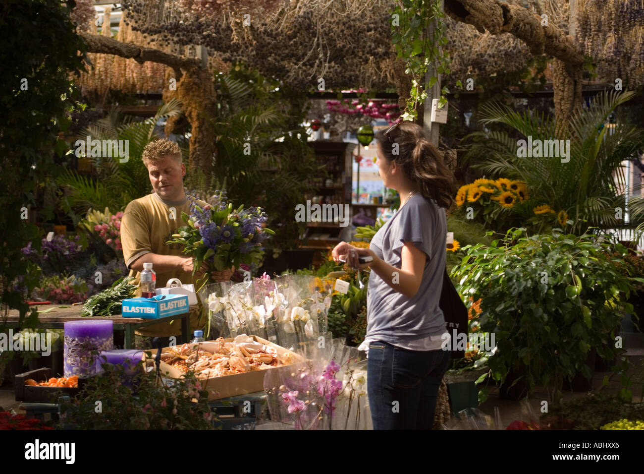 Donna acquistando un nuovo mazzo di fiori Bloemenmarkt Mercato dei Fiori Singel Gracht Amsterdam Olanda Paesi Bassi Foto Stock