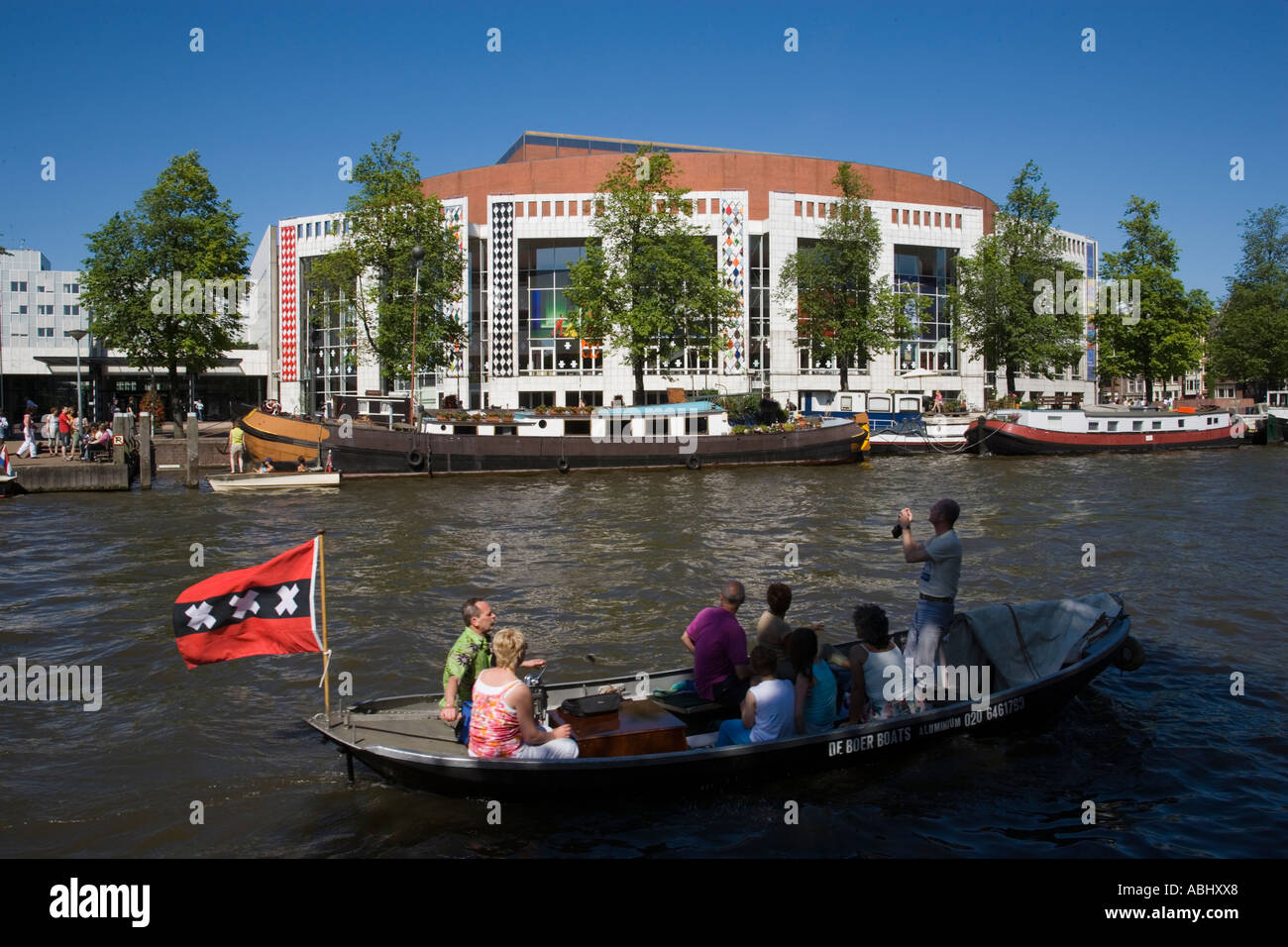 Persone in barca sul fiume Amstel passando la Stopera muziektheater di Amsterdam Amsterdam Paesi Bassi Paesi Bassi Foto Stock