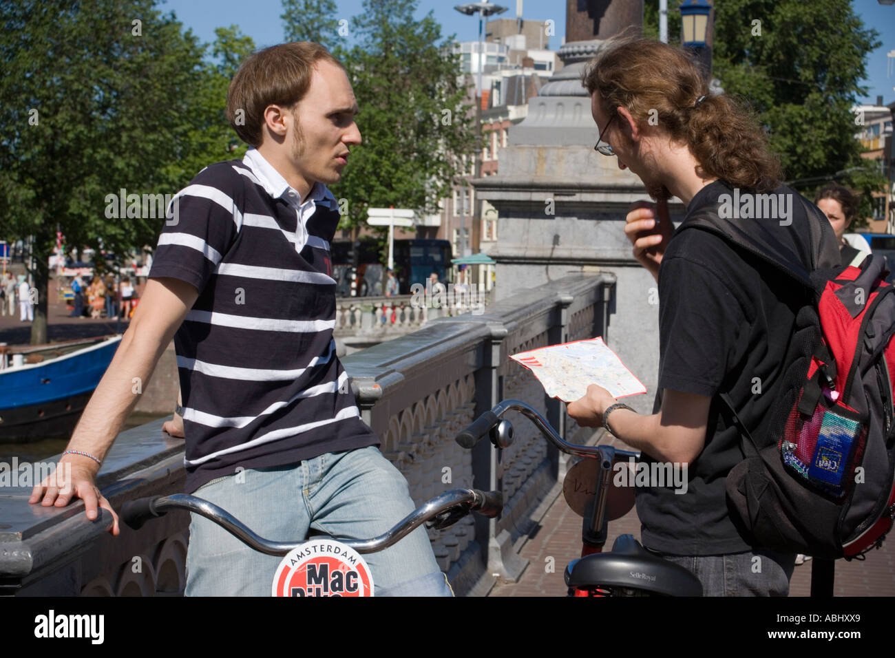 Due ciclisti cercando indicazioni sul lato ponte view Amsterdam Holland Olanda Foto Stock