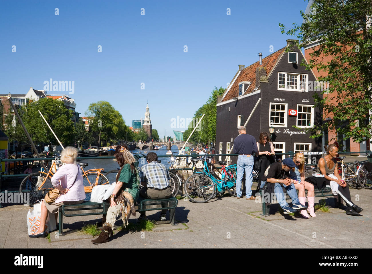Gente seduta sul ponte in prossimità di de Sluyswacht un brown cafè a canal Oude Schans Amsterdam Olanda Paesi Bassi Foto Stock