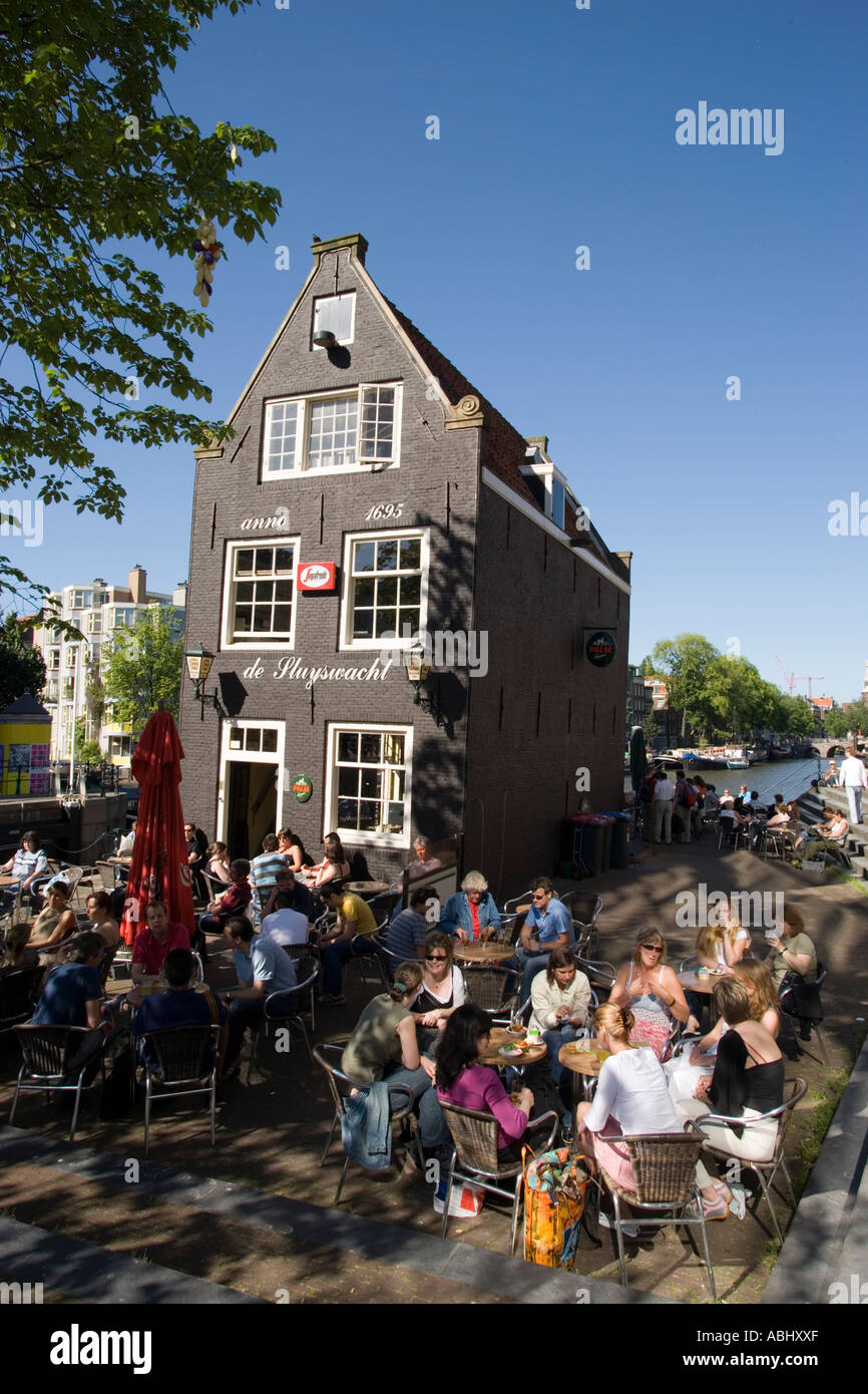 La gente seduta in aria aperta cafe davanti a de Sluyswacht un tipico brown cafè Amsterdam Olanda Paesi Bassi Foto Stock