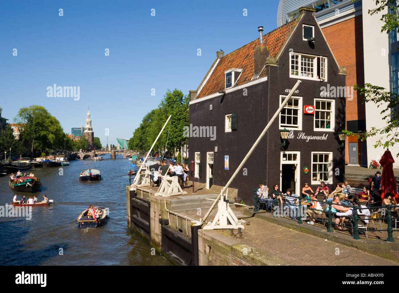 Barche da diporto sul canal Oude Schans passando de Sluyswacht un tipico brown cafè Amsterdam Olanda Paesi Bassi Foto Stock