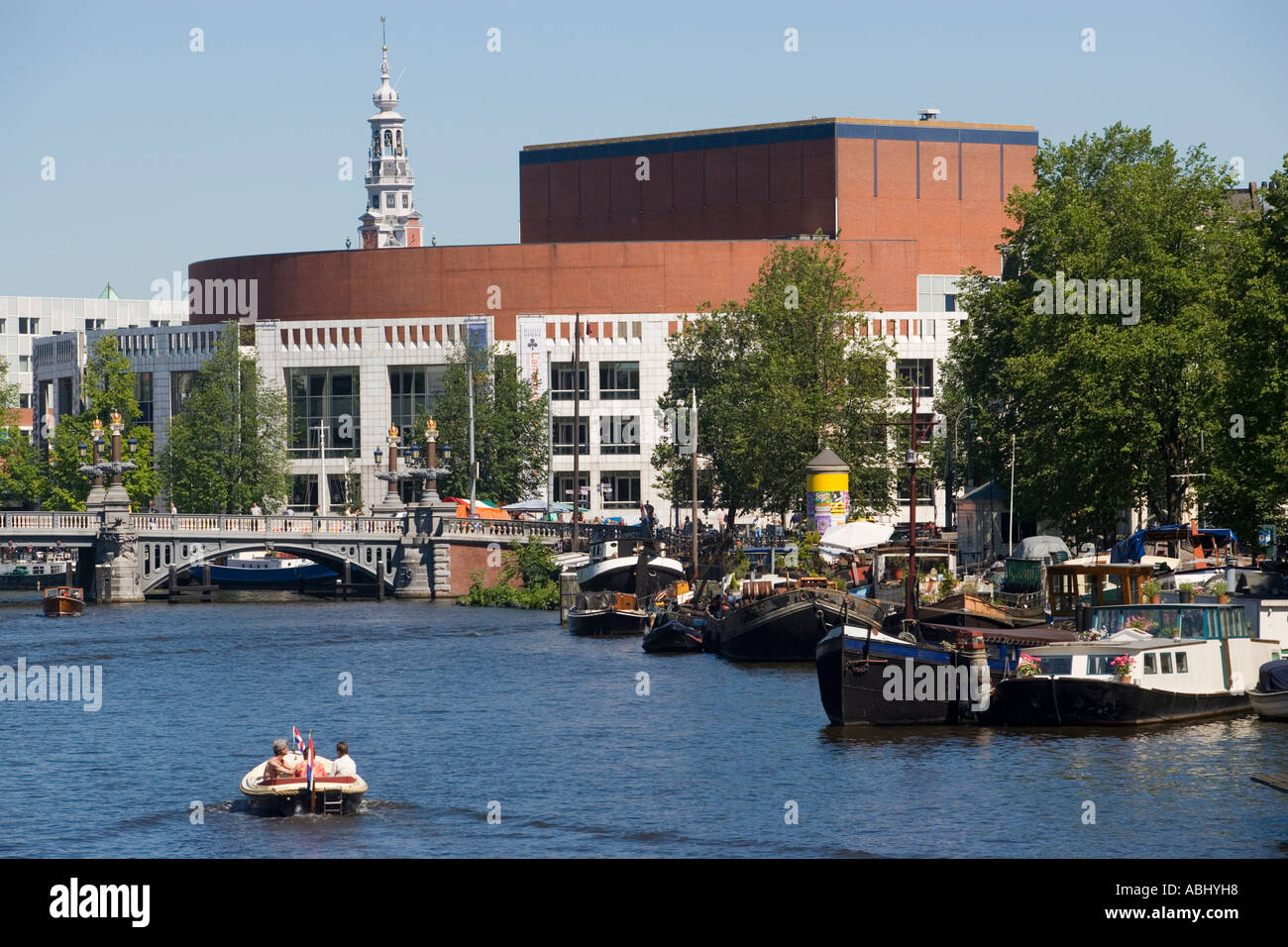 Persone in barca sul fiume Amstel passando la Stopera muziektheater di Amsterdam Amsterdam Paesi Bassi Paesi Bassi Foto Stock