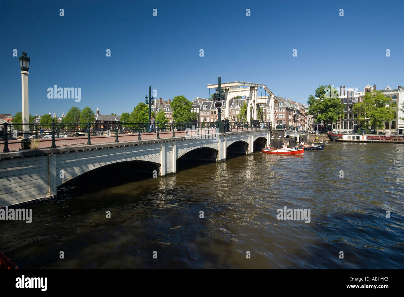 Tempo libero barche sul fiume Amstel in una giornata di sole Magere Brug Skinny Bridge in background Amsterdam Olanda Paesi Bassi Foto Stock