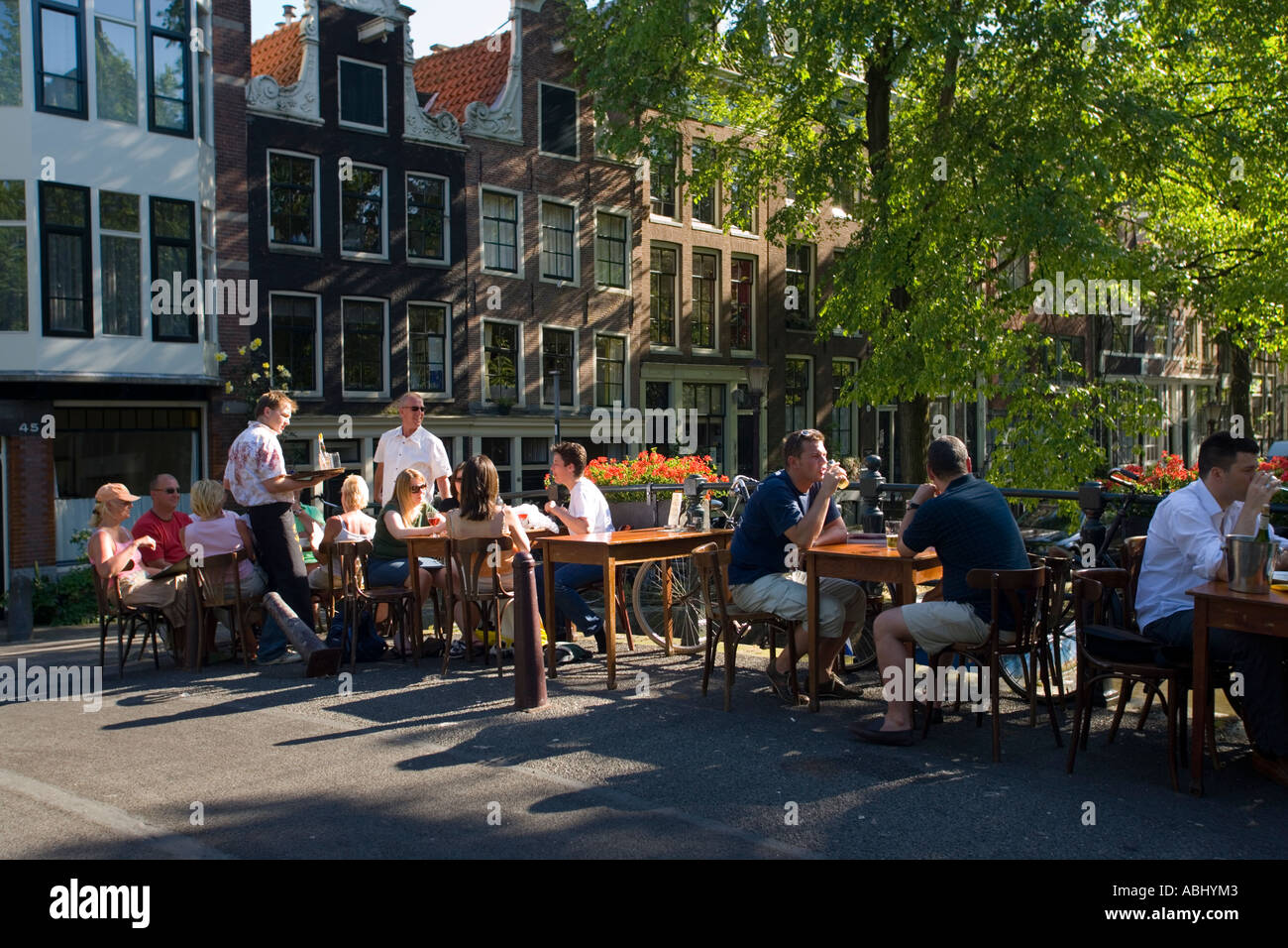 La gente seduta in ristorante a cielo aperto sul ponte sul canale su Egelantiersgrach Jordaan Amsterdam Olanda Antille Foto Stock