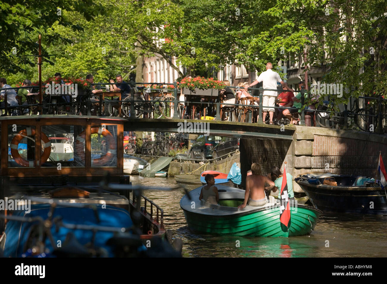 La gente seduta in aria aperta ristorante sul canal bridge over Egelantiersgracht Jordaan Amsterdam Olanda Paesi Bassi Foto Stock