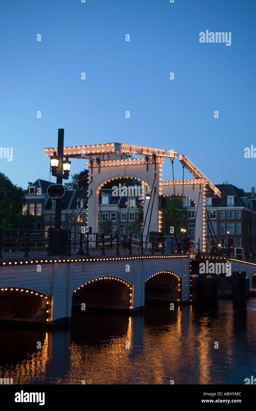 Illuminata Magere Brug Skinny Bridge in serata Amstel Amsterdam Holland Olanda Foto Stock