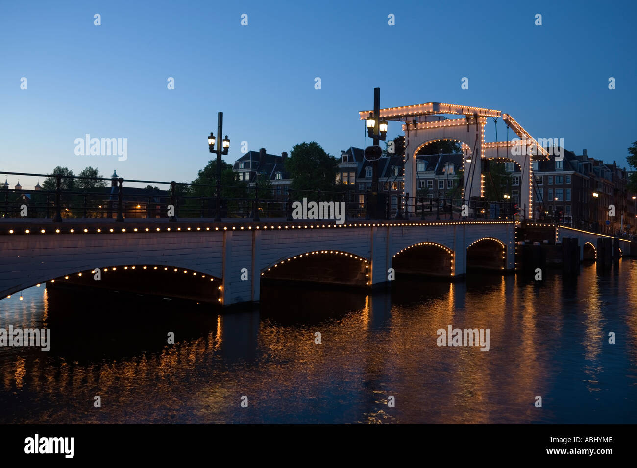 Illuminata Magere Brug Skinny Bridge in serata Amsterdam Olanda Paesi Bassi Foto Stock