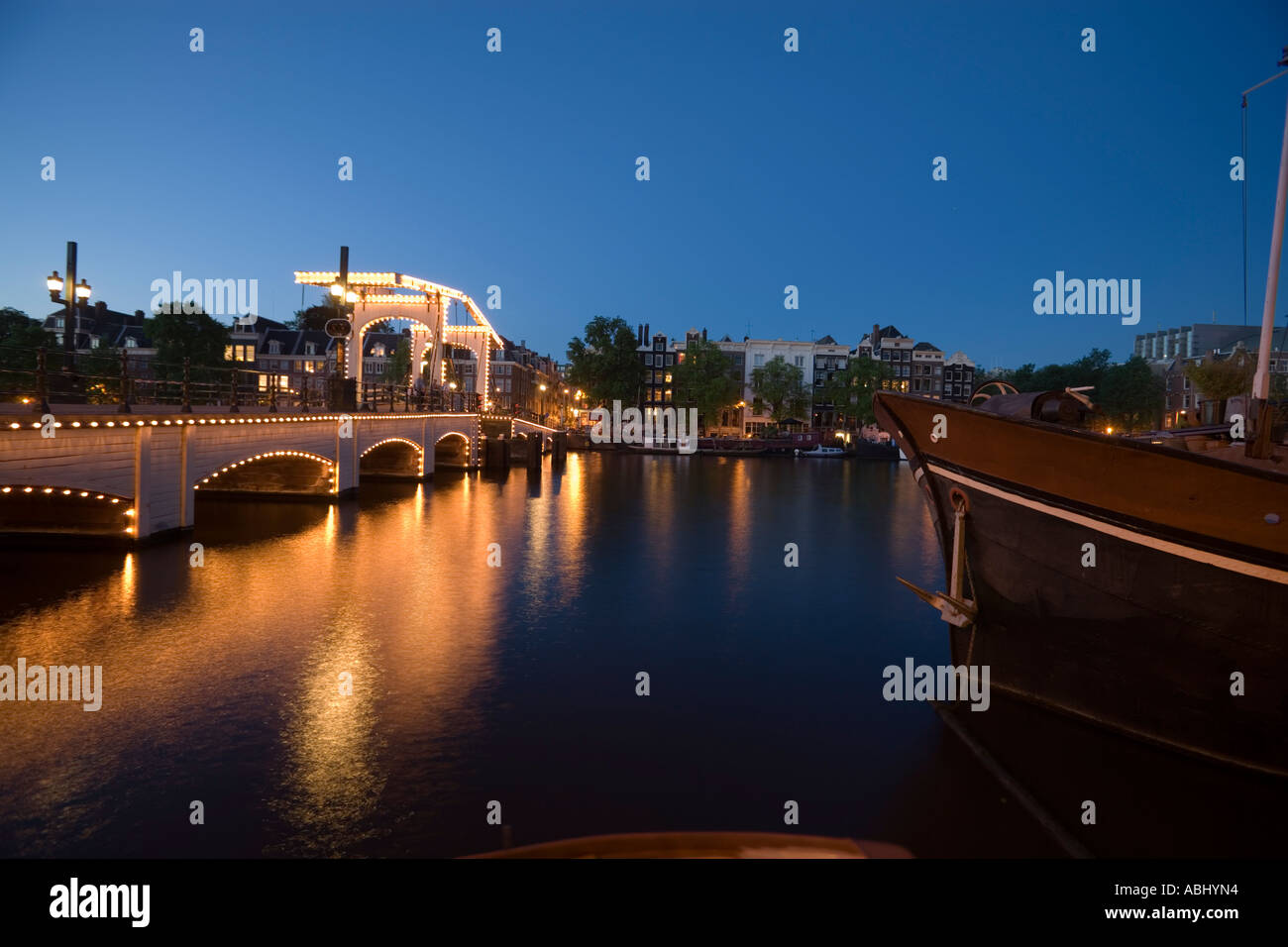 Illuminata Magere Brug Skinny Bridge in serata Amsterdam Olanda Paesi Bassi Foto Stock