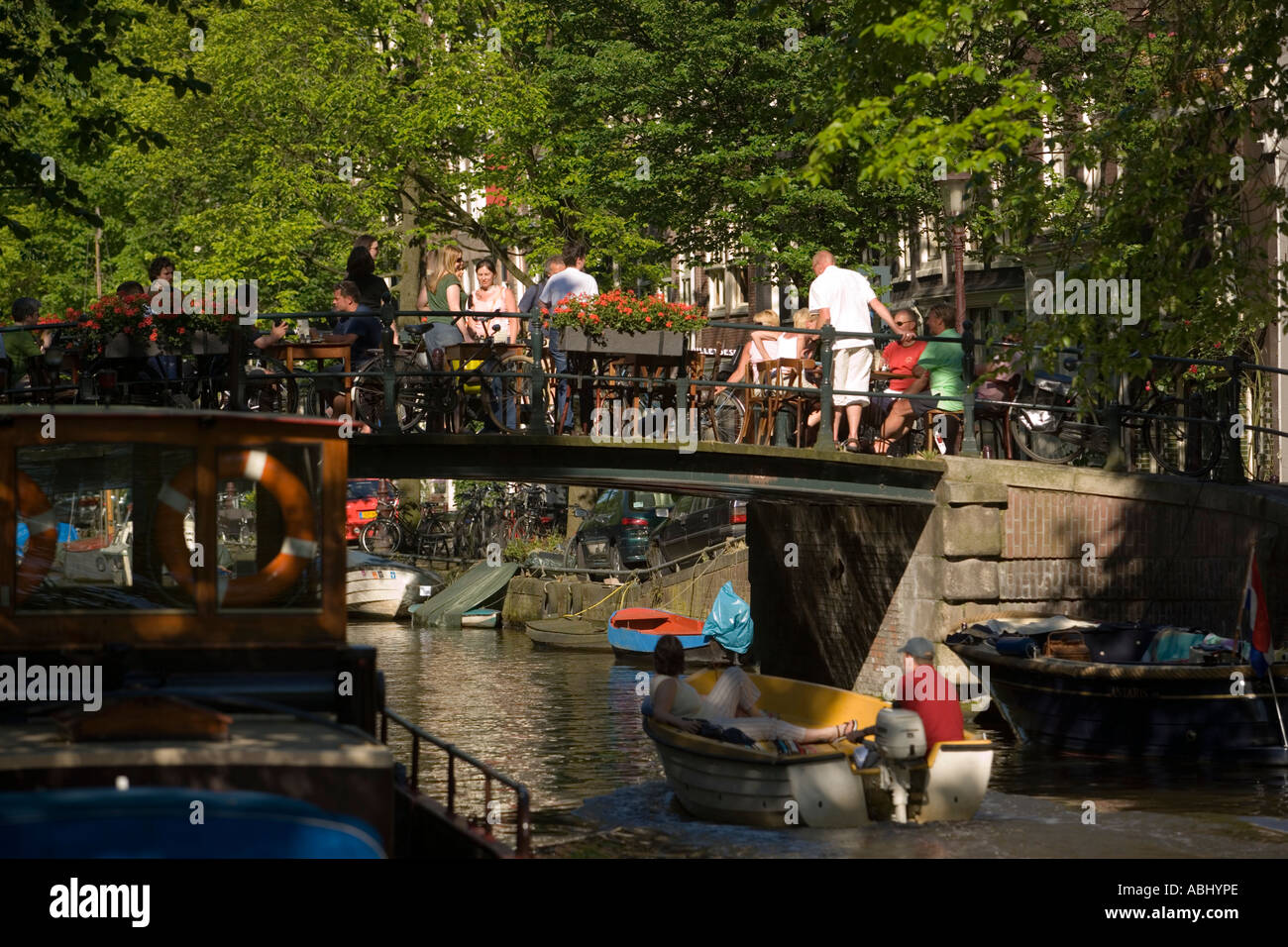 La gente seduta in aria aperta ristorante sul canal bridge over Egelantiersgracht Jordaan Amsterdam Olanda Paesi Bassi Foto Stock