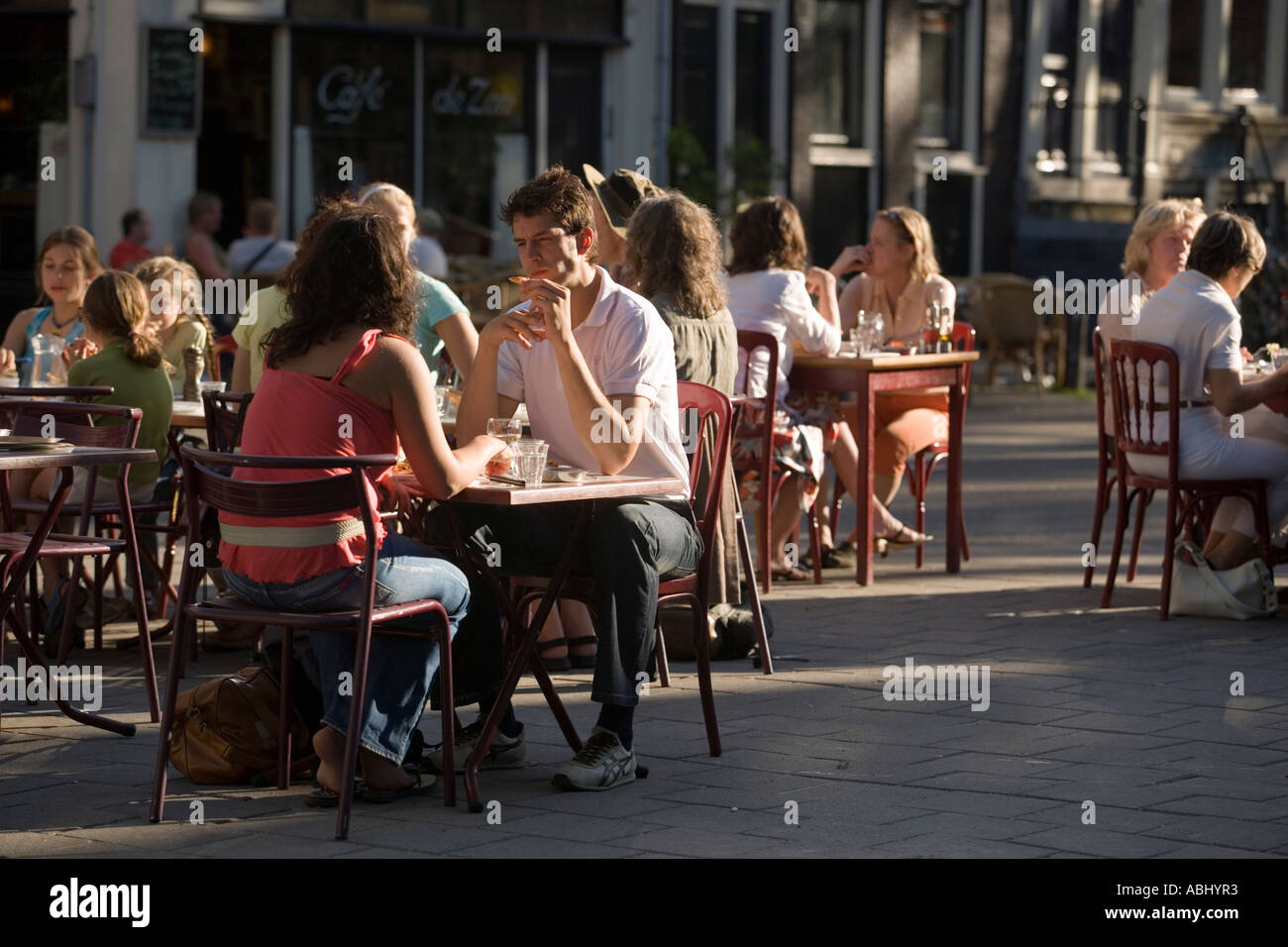 La gente seduta in un provvisorio ristorante a cielo aperto su una straordinaria giornata di caldo Lindengracht Jordaan Amsterdam Olanda Netherlan Foto Stock
