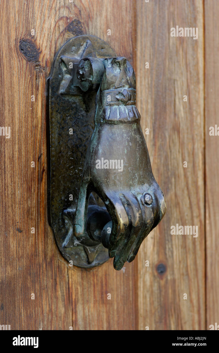 Vecchio ottone ossidato porta metallica respingente su una porta di legno Foto Stock