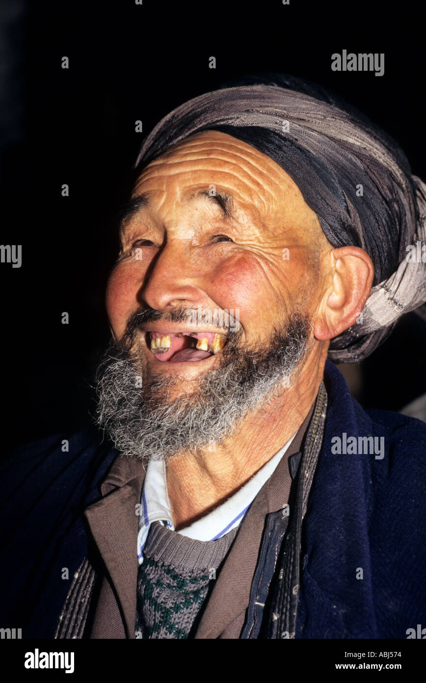 Samarcanda, Uzbekistan. Ritratto di un grinning vecchio uomo musulmano con n. di denti frontali, una barba grigia e argento turbante. Foto Stock