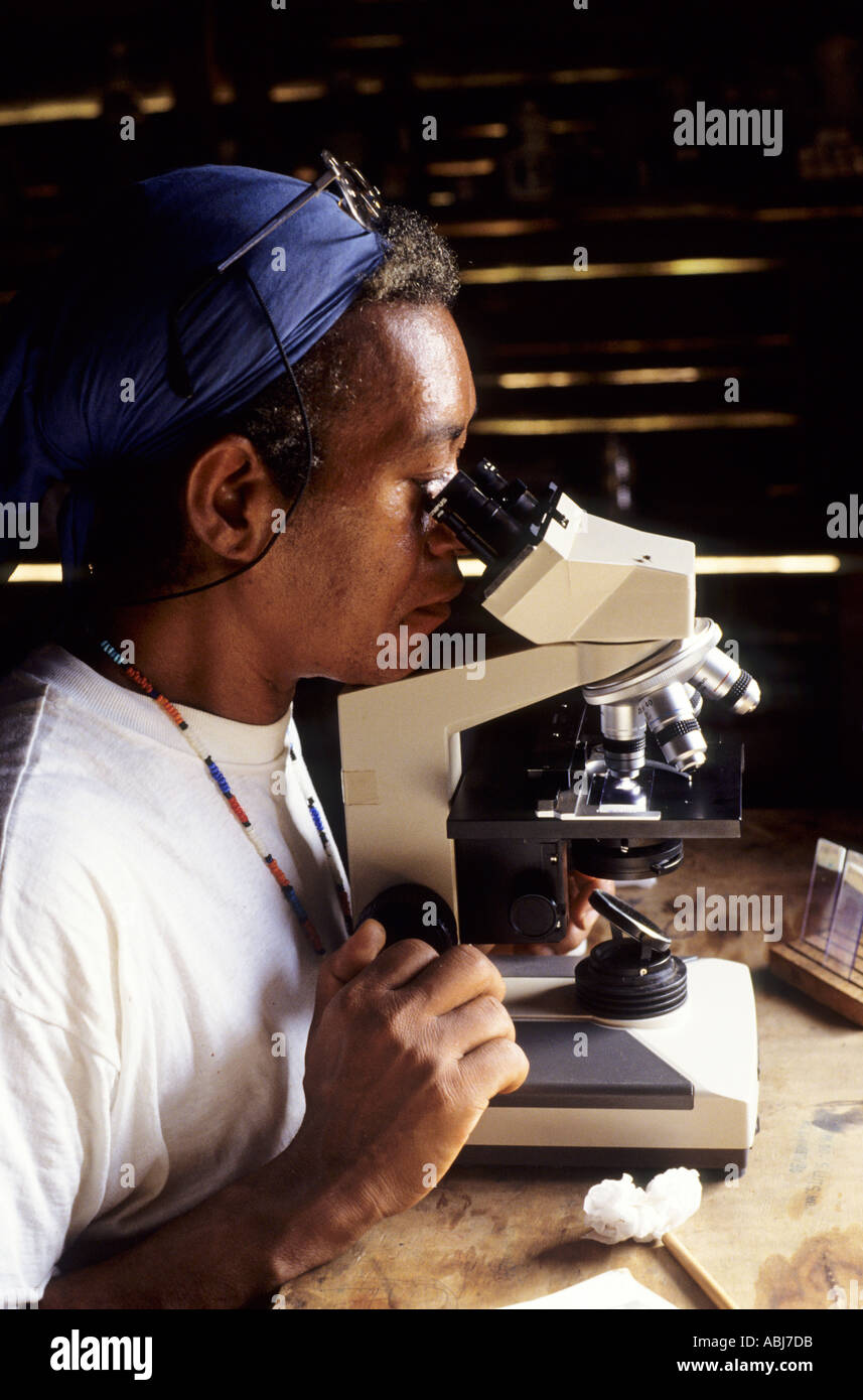 Paapiu, Brasile. Gli Yanomami post di salute, stato di Roraima. Una suora esaminando un campione da una vittima della malaria con un microscopio. Foto Stock