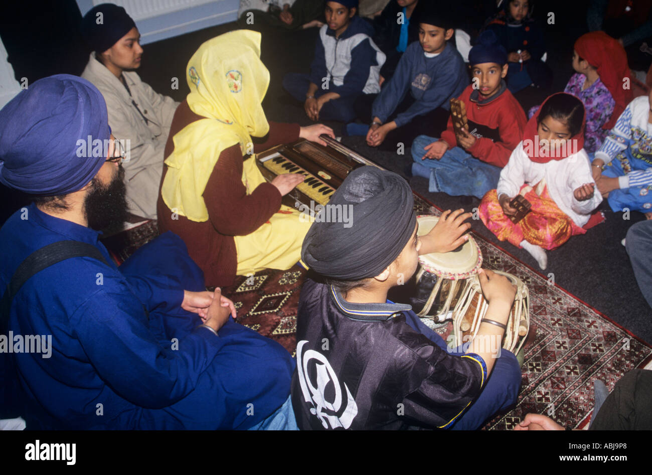I giovani Sikh imparano a suonare i vari strumenti utilizzati nel servizio gurdwara la domenica Foto Stock