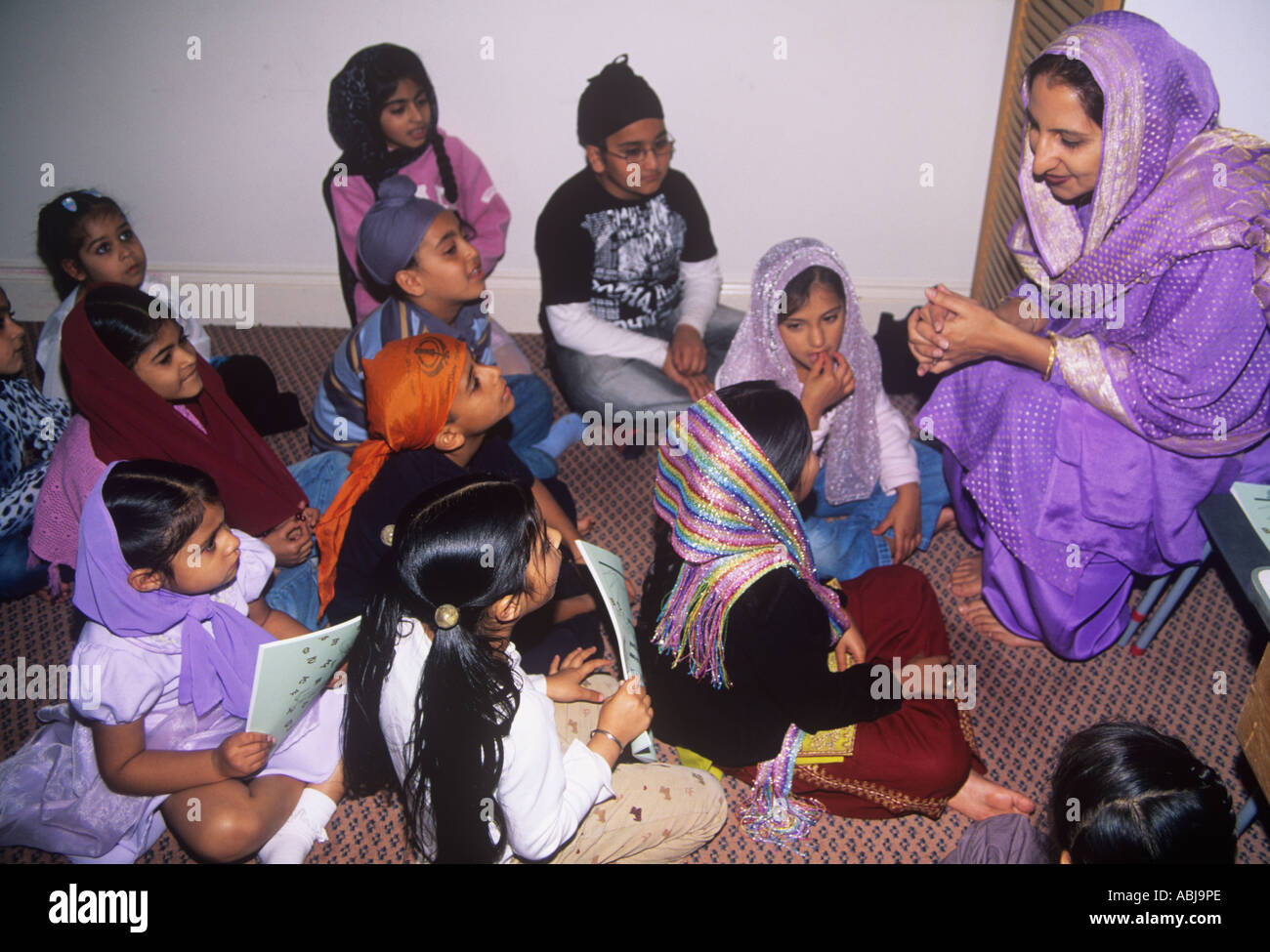 Lezione di scuola domenicale per i bambini Sikh in una stanza della gurdwara Foto Stock