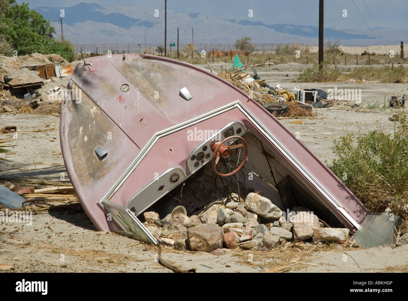 Speedboat sepolto dal lato della strada, Salton Sea Beach, Souther California, Stati Uniti d'America. Foto Stock