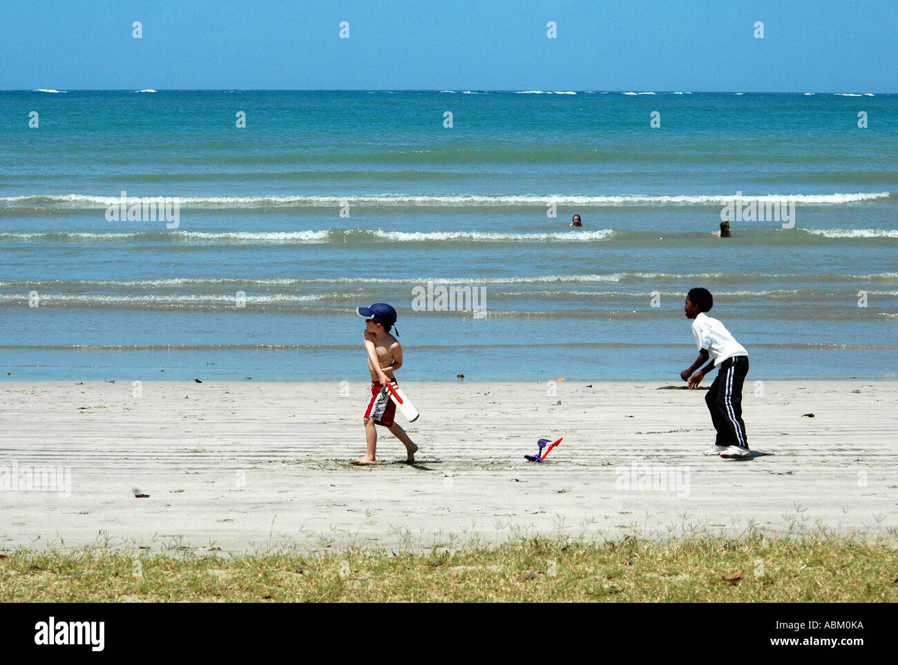 Ragazzi giocare a cricket sulla spiaggia Foto Stock