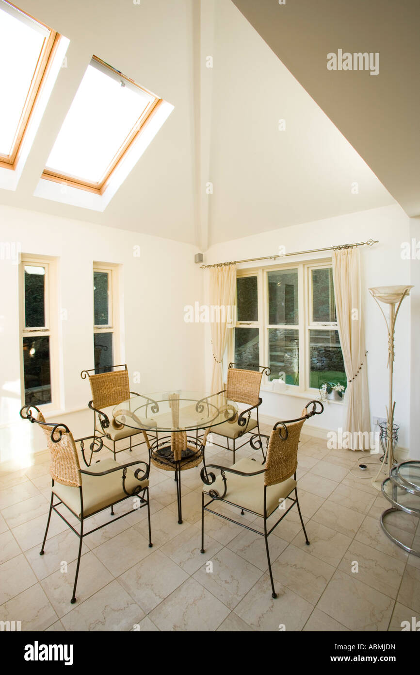Tavolo e sedie in una stanza ben illuminata con tetto finestre Velux Foto Stock