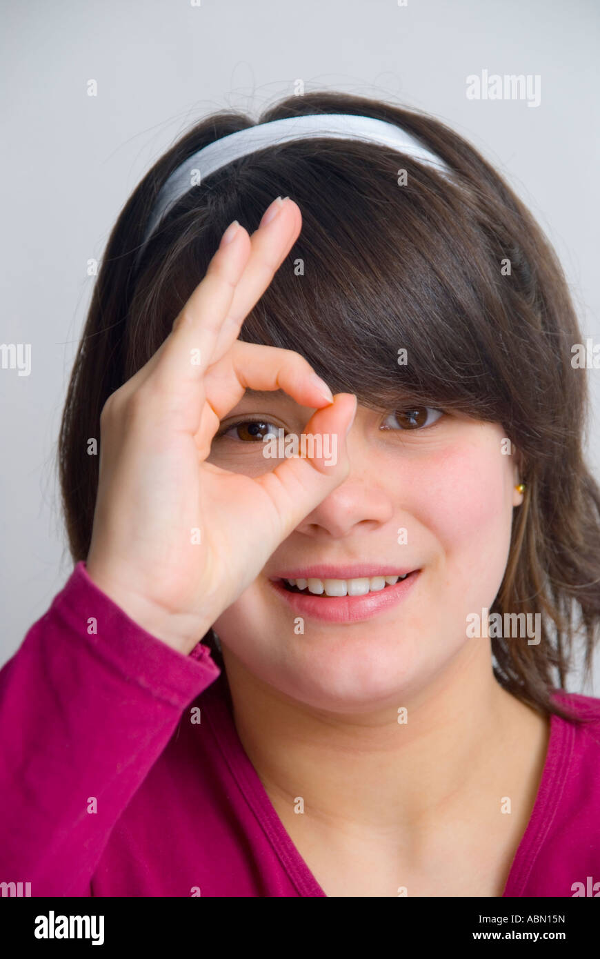 Giovani 11 anno vecchia ragazza dando il segno OK Foto Stock