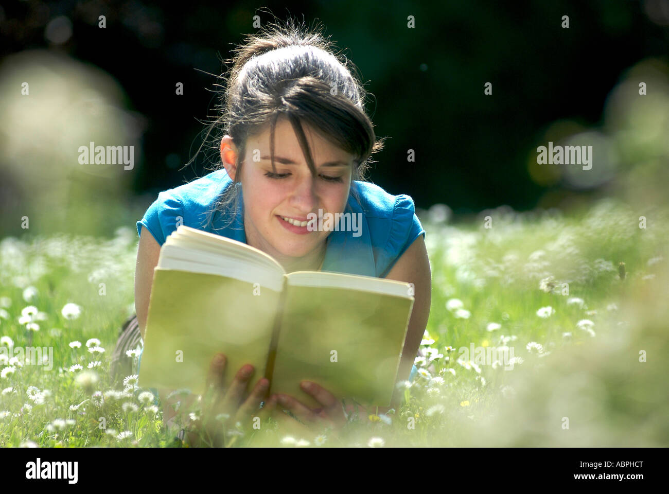 Teen girl leggendo un libro al di fuori Foto Stock