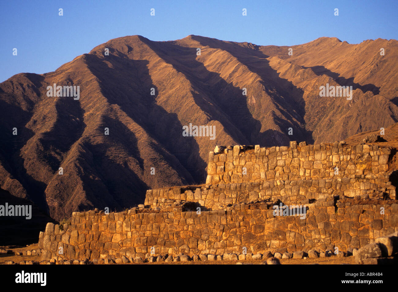Chinchero, Perù. Inca muratura muri in pietra con profondamente eroso montagne dietro. Foto Stock