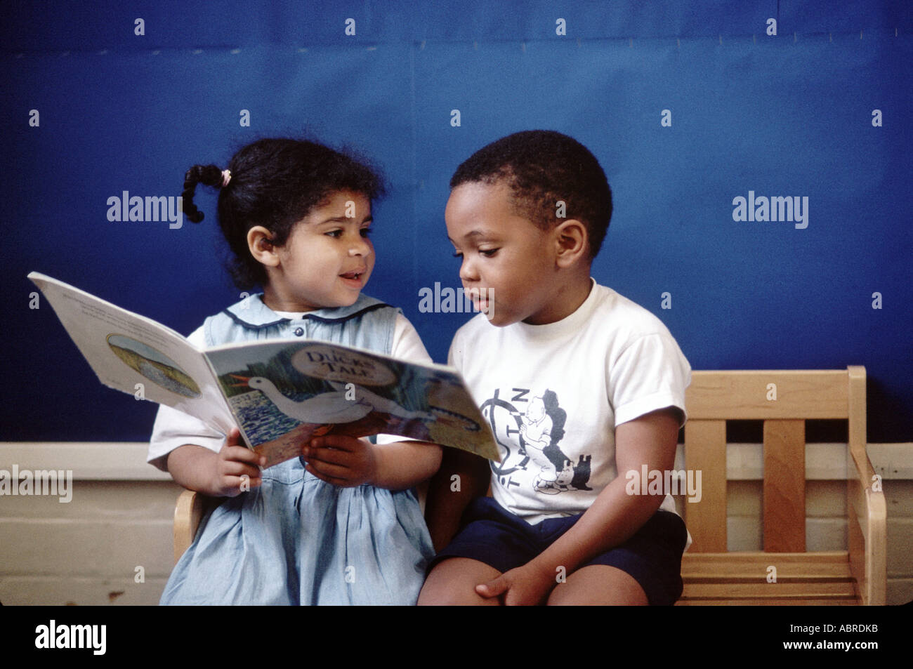 Bambini della scuola materna la lettura di un libro Foto Stock