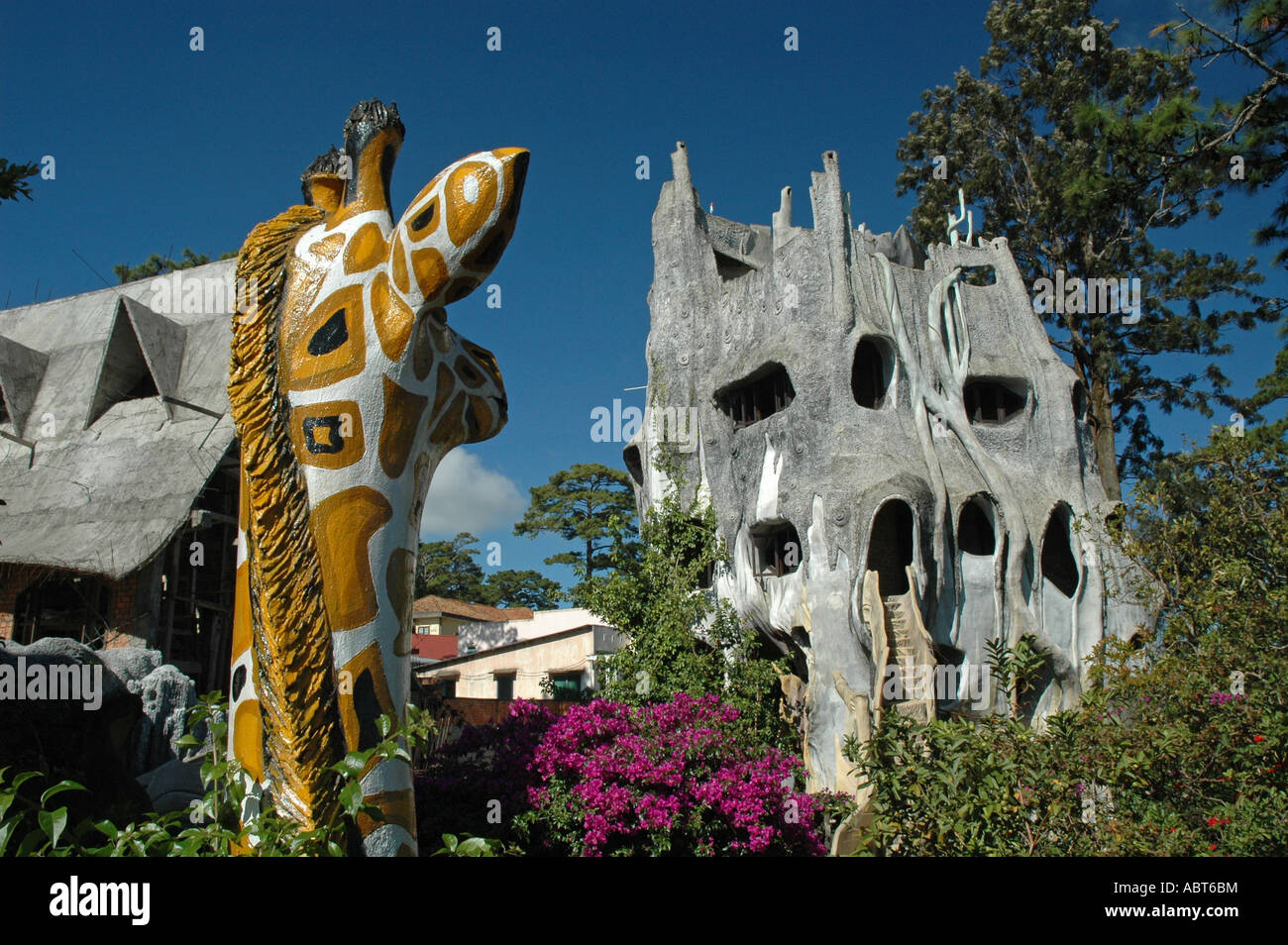 Una giraffa si affaccia su architetto ed artista appendere Viet Nga's Crazy House a Dalat nelle Highlands Meridionali del Vietnam. Foto Stock