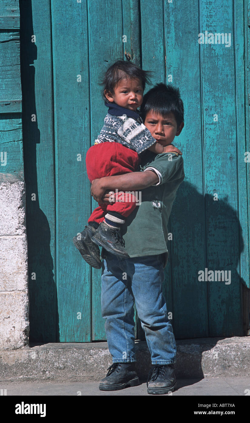 Ragazzo guatemalteco portando il suo fratello più giovane San Pedro Sacatepequez Guatemala America Centrale Foto Stock