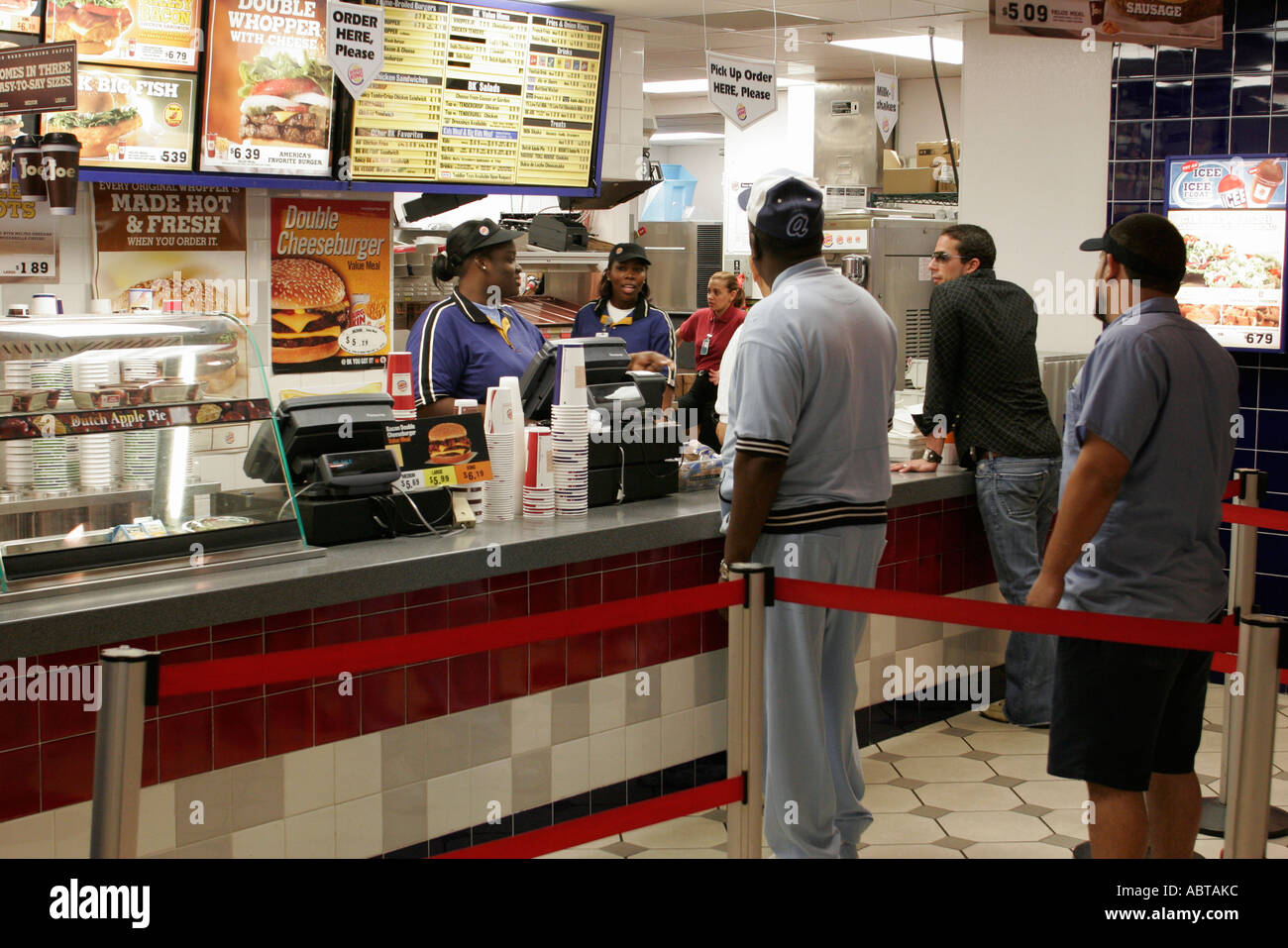 Florida,Miami Airport,Burger King, ristorante clienti clienti fast food ordinare bancone line coda,donna nera donne donne,uomo uomini maschio,lavoratore Foto Stock