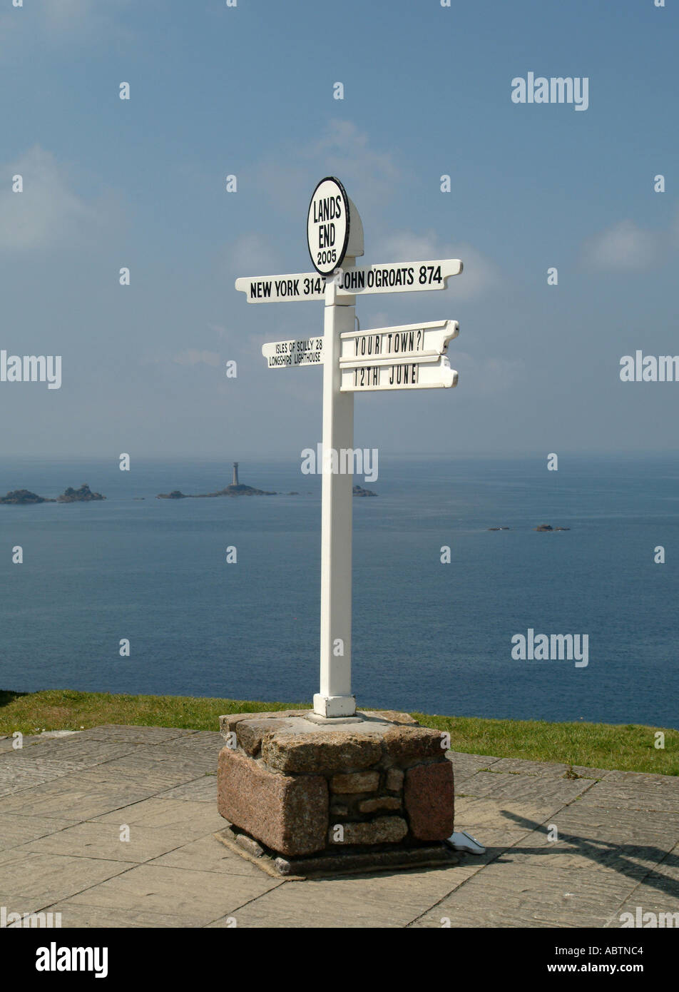 Il famoso cartello a Lands End con Longships Lighthouse in background Cornwall Inghilterra Regno Unito Regno Unito Foto Stock