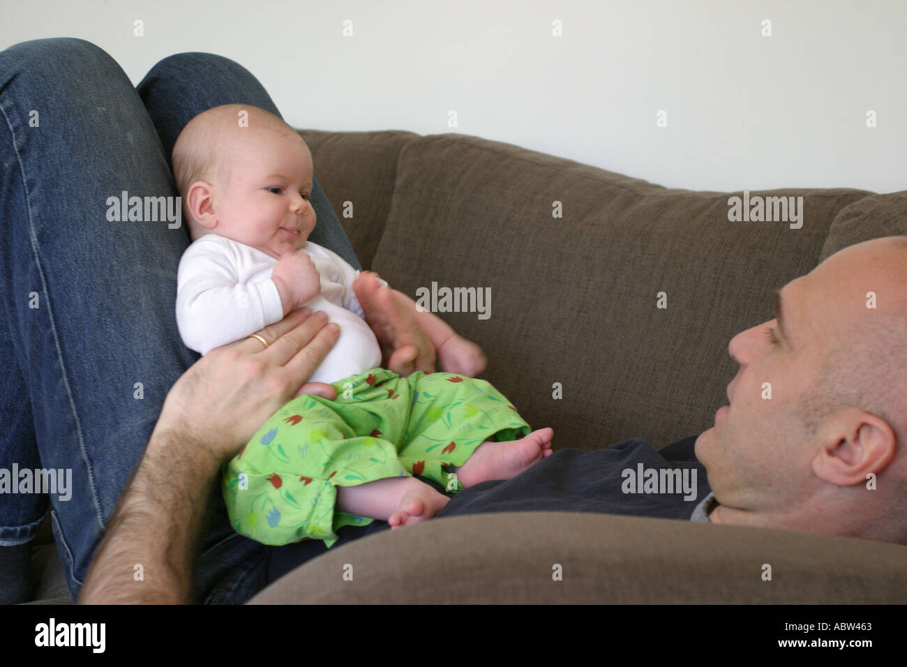 Un padre gioca con la sua figlia seduta sul divano di casa, Svezia. Foto Stock