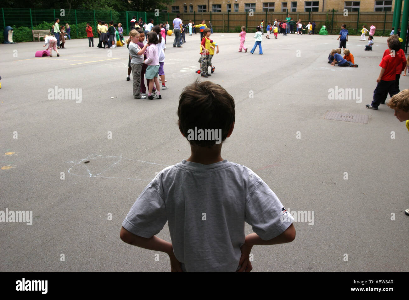 Un bambino da solo in una scuola parco giochi, Londra Scuola Junior. Foto Stock