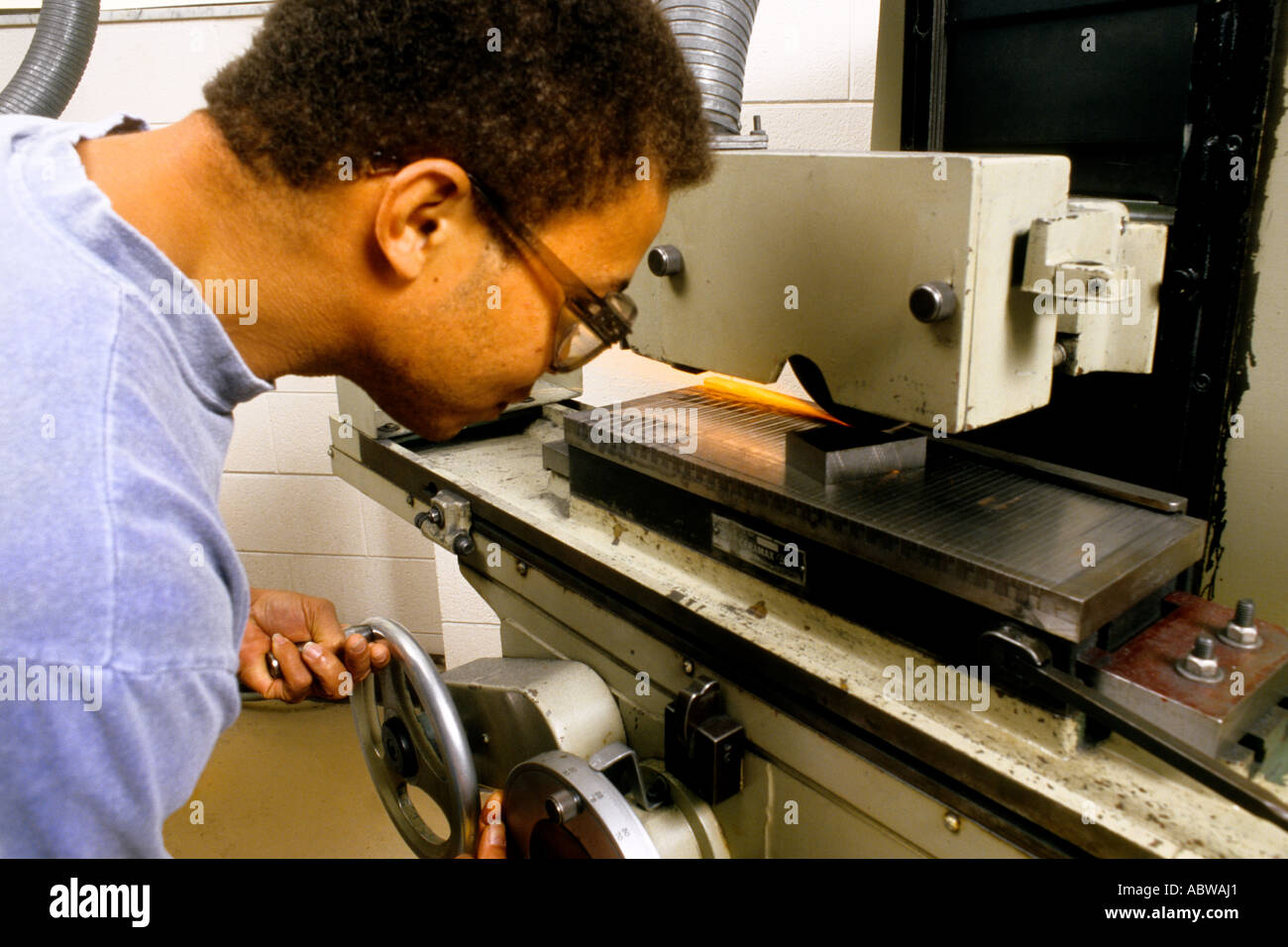 Collegio maschile studente lavora in un negozio di classe sul tornio macchinari con precauzioni di sicurezza Foto Stock