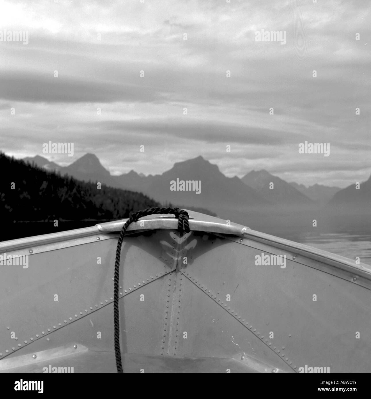 Immagine in bianco e nero di una barca sul lago con le montagne sullo sfondo. Foto Stock