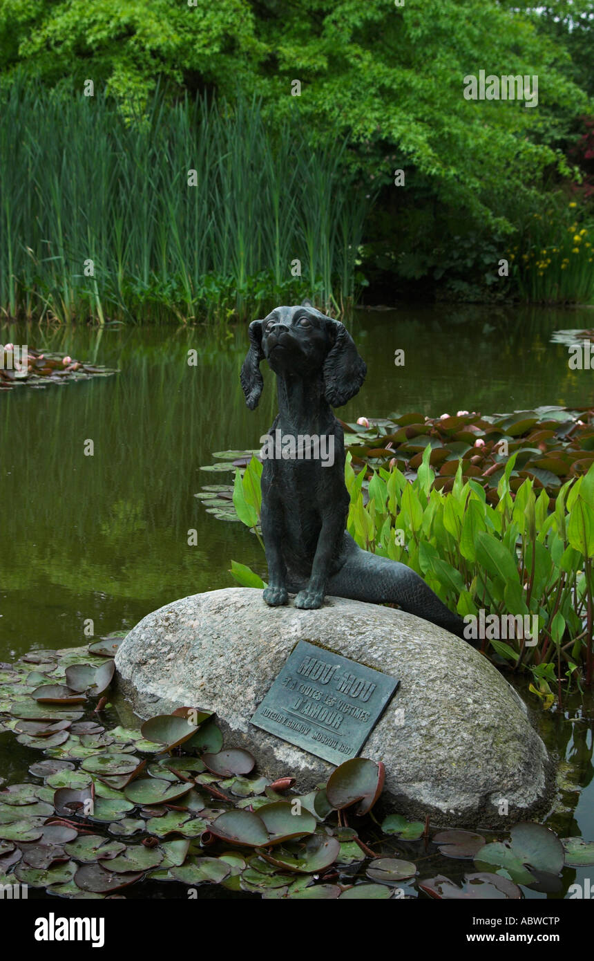 Figura in bronzo di bestia fantastico mezzo cane, metà pesce su una roccia in uno stagno Foto Stock