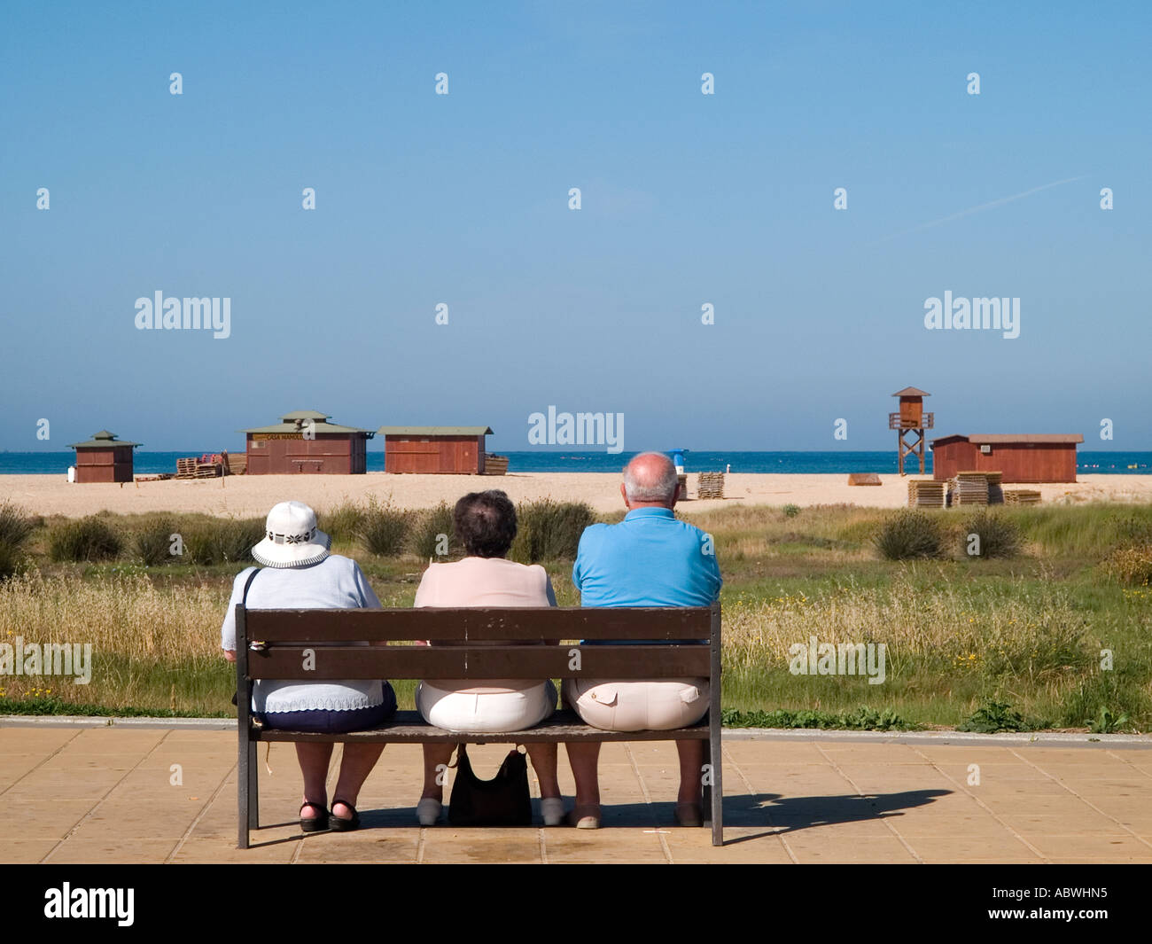 Tre persone sedute su una panchina. Foto Stock