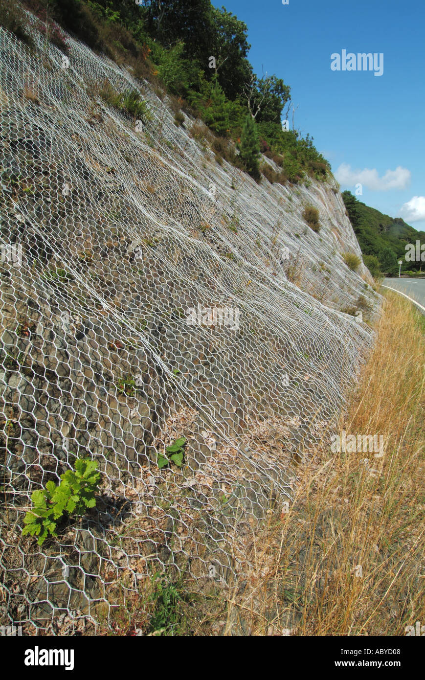 Vicino a Blaenau Ffestiniog strada scogliera ricoperta in pesante lavoro a rete di filo per contribuire a contenere detriti di roccia caduta sulla strada Foto Stock