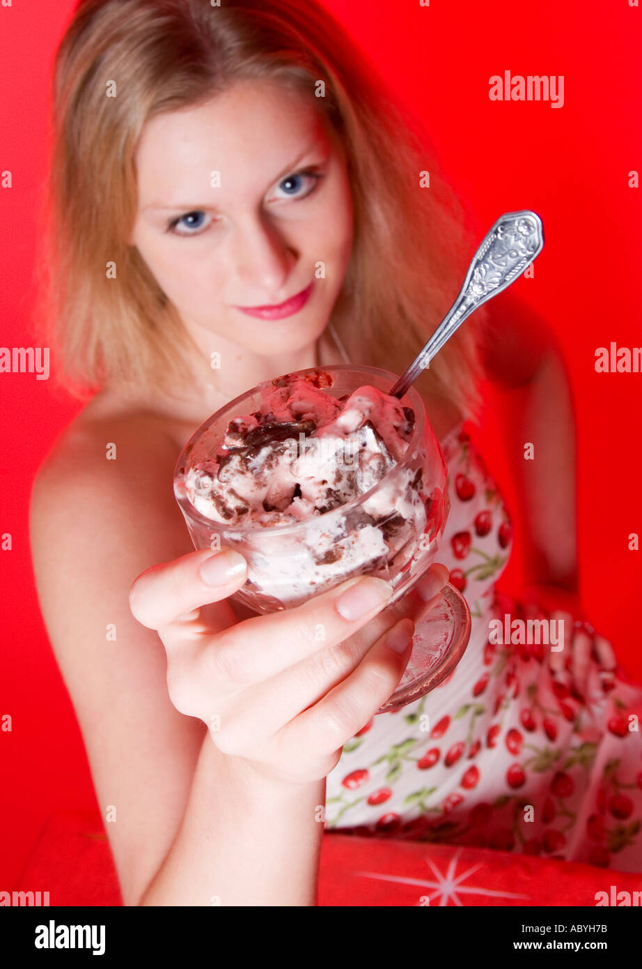 Donna con un abito a motivi di ciliegia che regge una ciotola di gelato alla ciliegia, USA. Foto Stock